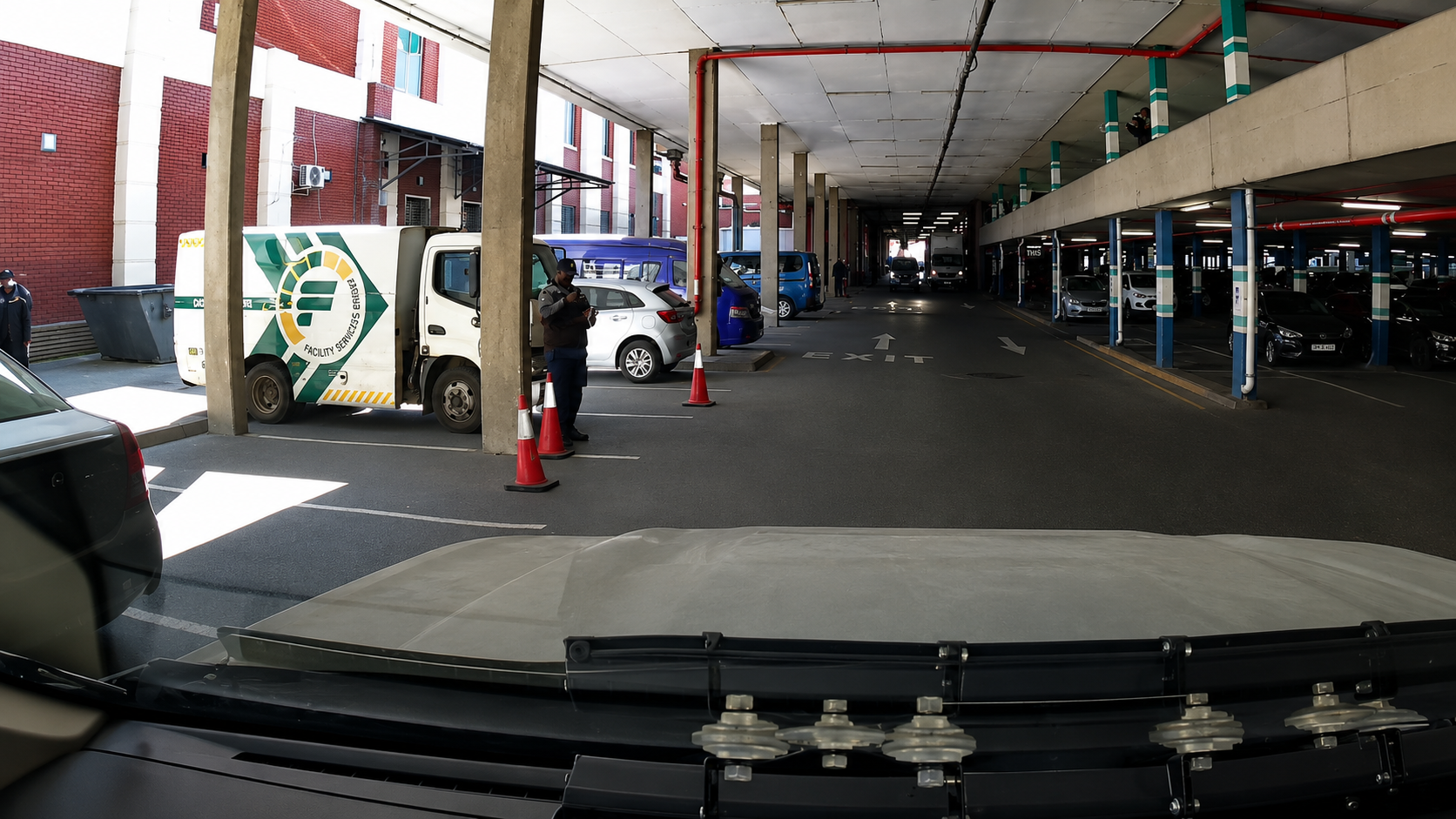 View from a NoJack response vehicle entering the Lakeside Mall parking level, with a cash-in-transit vehicle and a security officer at the scene