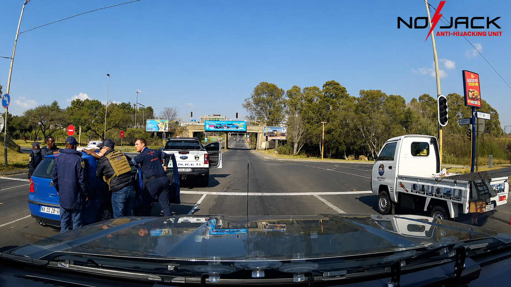 SAPS members and NoJack response teams processing the suspect vehicle at a Benoni intersection after the arrest